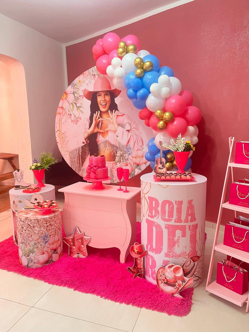 Decoração de festa tema boiadeira com painel, balões e bolo rosa