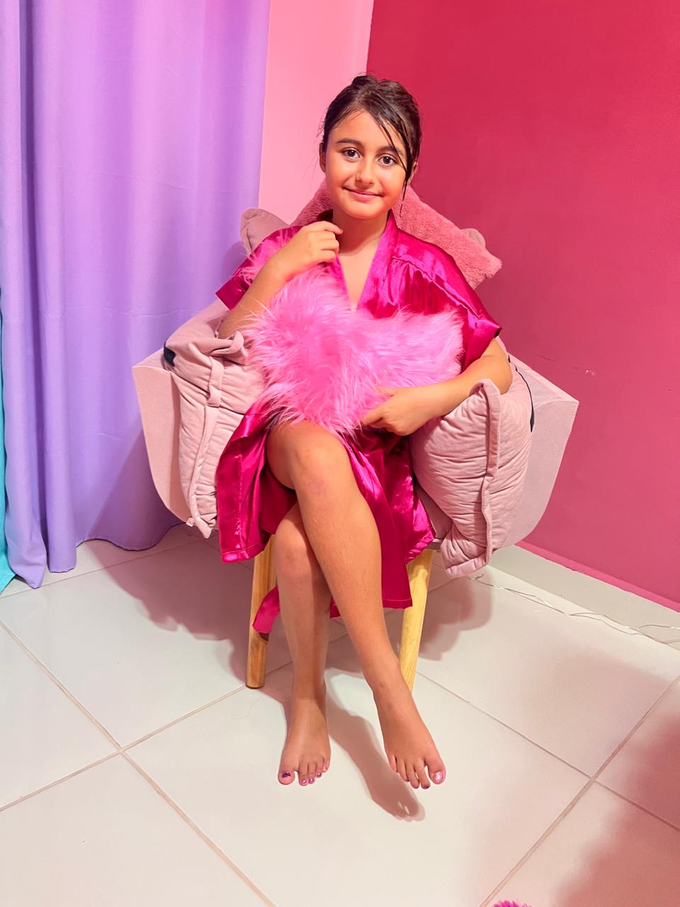 Princesa de roupão rosa na poltrona do spa